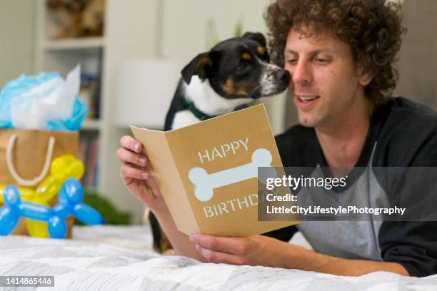 happy birthday to my dog - man reading card stock pictures, royalty-free photos & images