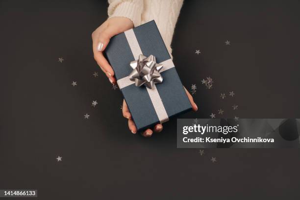 gift box wrapped in black in female hand. copy space. top view. black friday. - camarote - fotografias e filmes do acervo