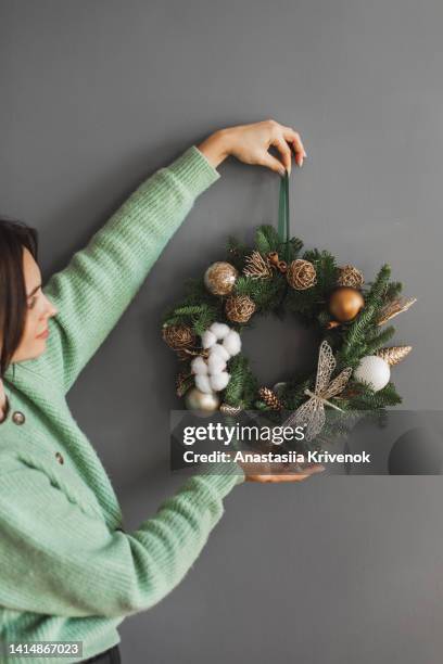 woman carrying a fresh christmas wreath. - advent kerze stock-fotos und bilder