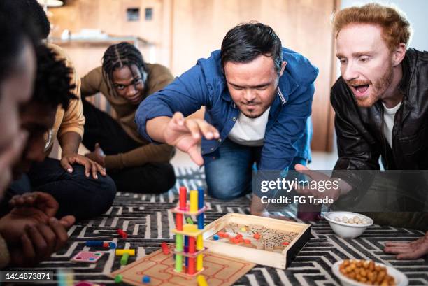 special needs boy playing board game with friends at home - bordspel stockfoto's en -beelden