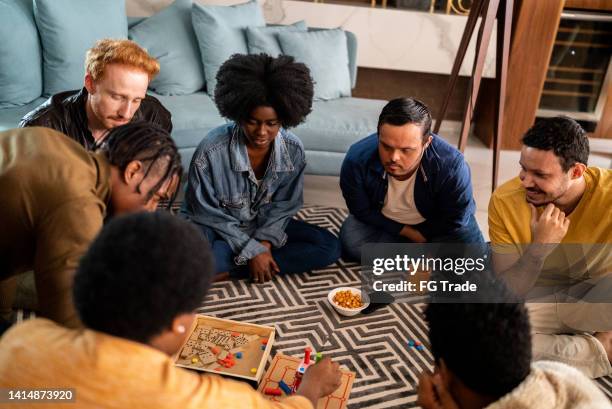 friends playing board game at home - reünie sociaal stockfoto's en -beelden
