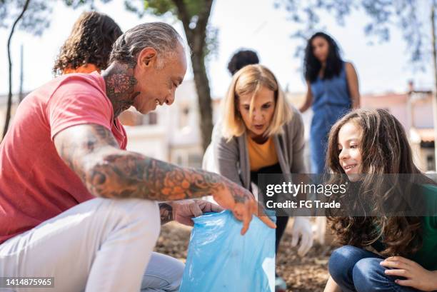 people picking up garbage to clean a public park - old woman tattoos stock pictures, royalty-free photos & images