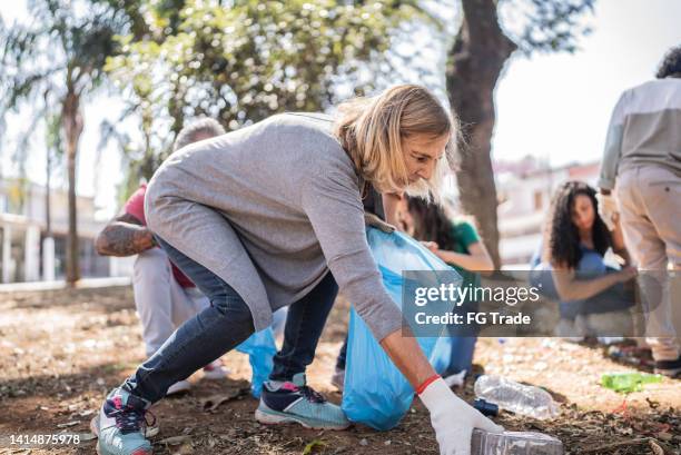 people picking up garbage to clean a public park - people picking up trash stock pictures, royalty-free photos & images