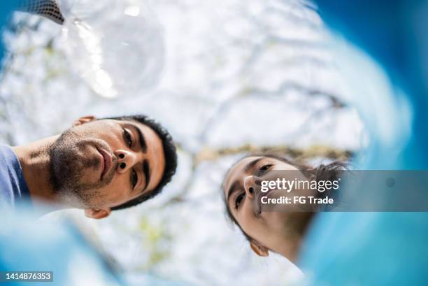 punto de vista de la bolsa de plástico de una pareja haciendo reciclaje - punto de vista de una cámara fotografías e imágenes de stock