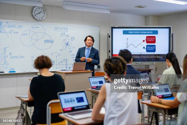 professor teaching mid adult and mature students at a community college - asian students classroom computer stock pictures, royalty-free photos & images