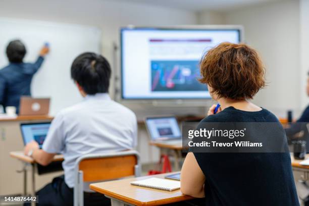 mid adult woman in a continuing education class at a community college or university - workshop 個照片及圖片檔