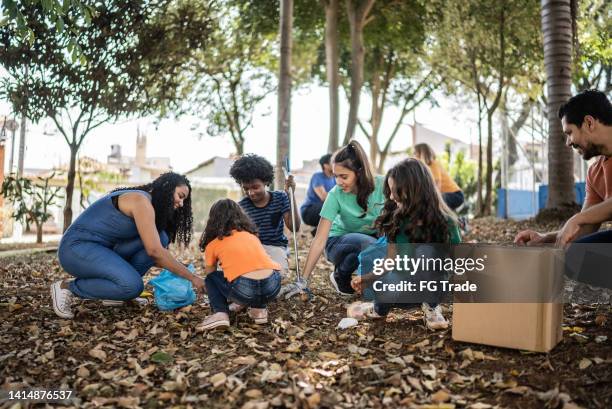 people picking up garbage to clean a public park - altruismo stock pictures, royalty-free photos & images