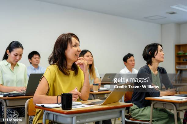 mid adult woman in a continuing education class at a community college or university - participant stock pictures, royalty-free photos & images