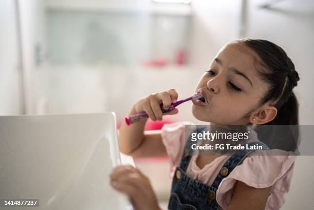 kleines mädchen, das sich zu hause im badezimmer die zähne putzt - tiny mexican girl stock-fotos und bilder
