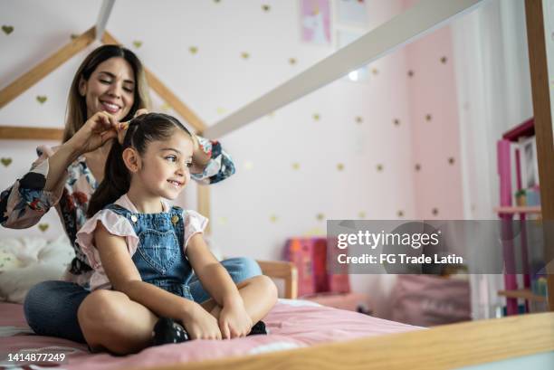 mother combing daughter's hair at home - adjusting hair stock pictures, royalty-free photos & images