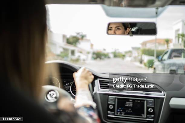 mid adult woman driving a car - inside car stockfoto's en -beelden