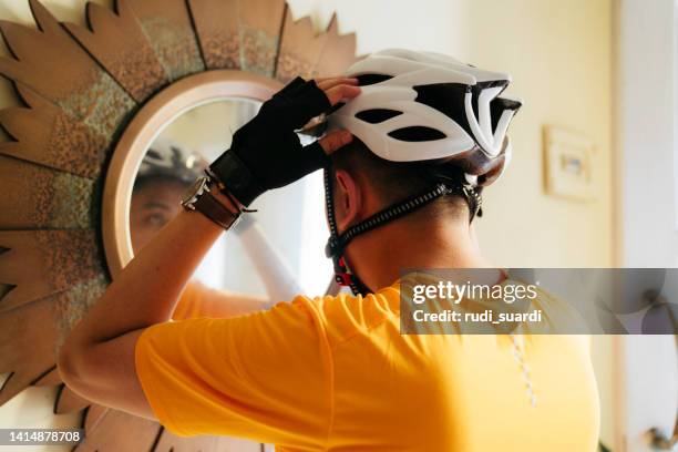 hombre poniéndose el casco en casa - correa accesorio personal fotografías e imágenes de stock
