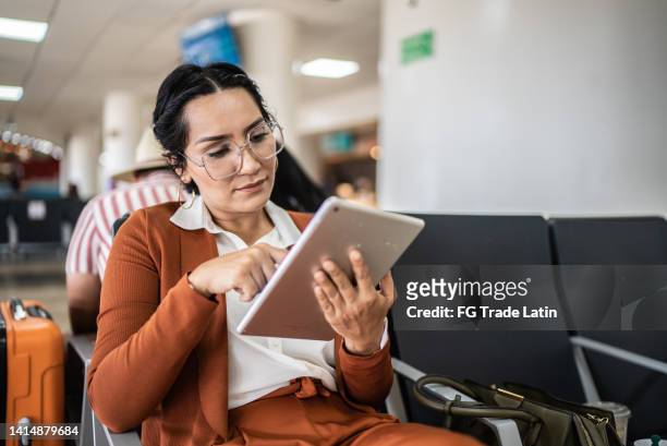 businesswoman using digital tablet in the departure area at airport - underground walkway stock pictures, royalty-free photos & images