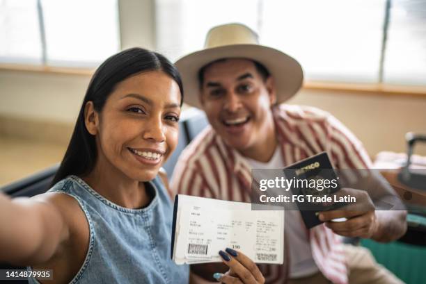 pareja tomándose una selfie con pasaporte y boleto de avión - punto de vista de la cámara - pasaporte mexicano fotografías e imágenes de stock