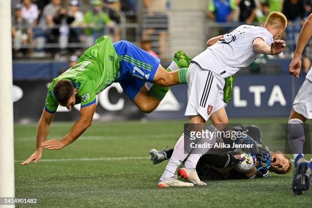 Zac MacMath of Real Salt Lake grabs the ball while Will Bruin of Seattle Sounders dives over during the second half at Lumen Field on August 14, 2022...