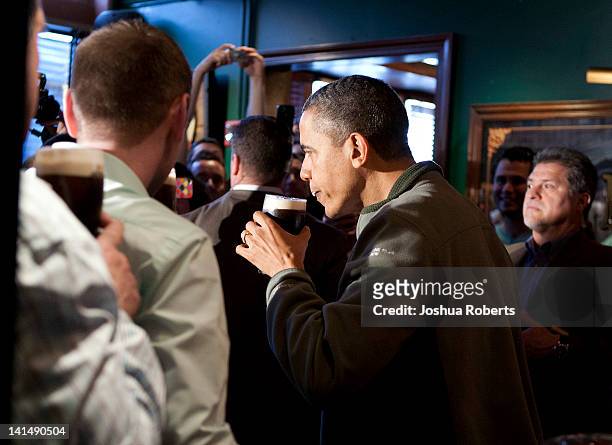 President Barack Obama takes a sip of Guinness beer as he visits a bar in celebration of St. Patrick's day at the Dubliner Restaurant and Pub on...