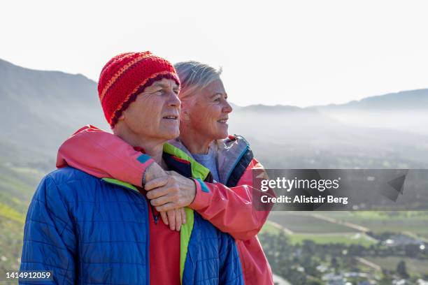 senior couple enjoying the view from the top of a mountain hike - table mountain cape town imagens e fotografias de stock