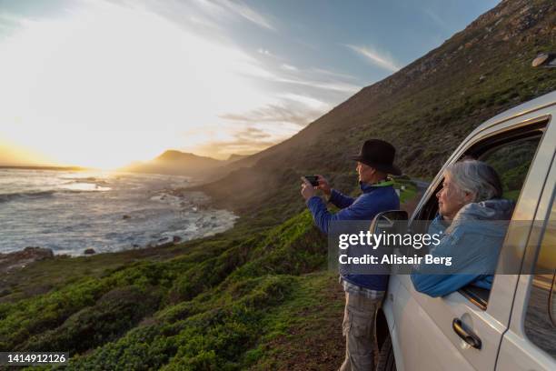 senior couple enjoying sunset by the sea - sea iphone stock pictures, royalty-free photos & images