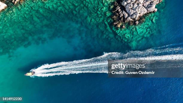 luxury speed boat floating in open sea at summer, yacht sailing in sea at hot summer day, seashore of mediterranean sea at summer, cruise speed boat floating in sea along rocky mountain coastline of mediterranean sea - rijkdom boot stockfoto's en -beelden