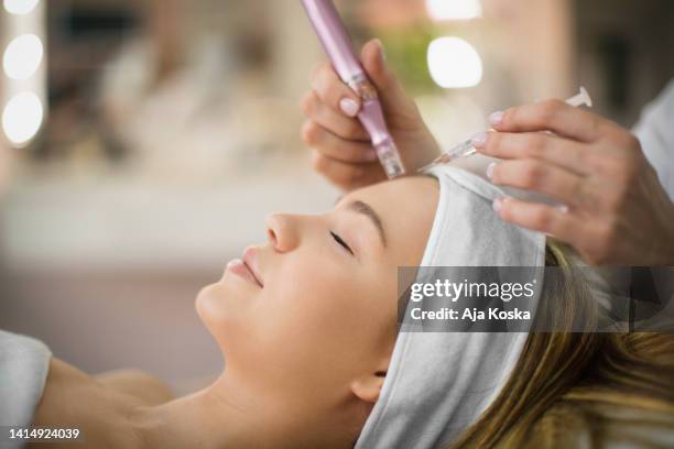 enjoying facial treatment  in a beauty salon. - hälsosalong bildbanksfoton och bilder