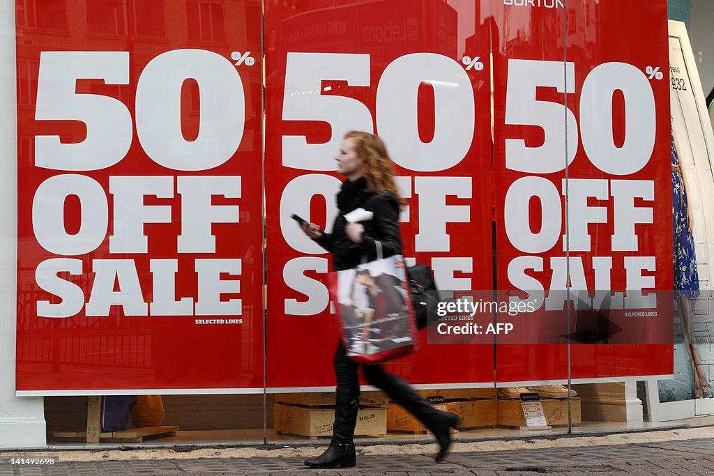 A woman holding shopping bags walks past