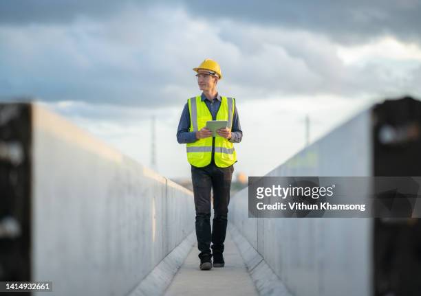 male engineer working with tablet at construction site. - architekt helm plan stock-fotos und bilder