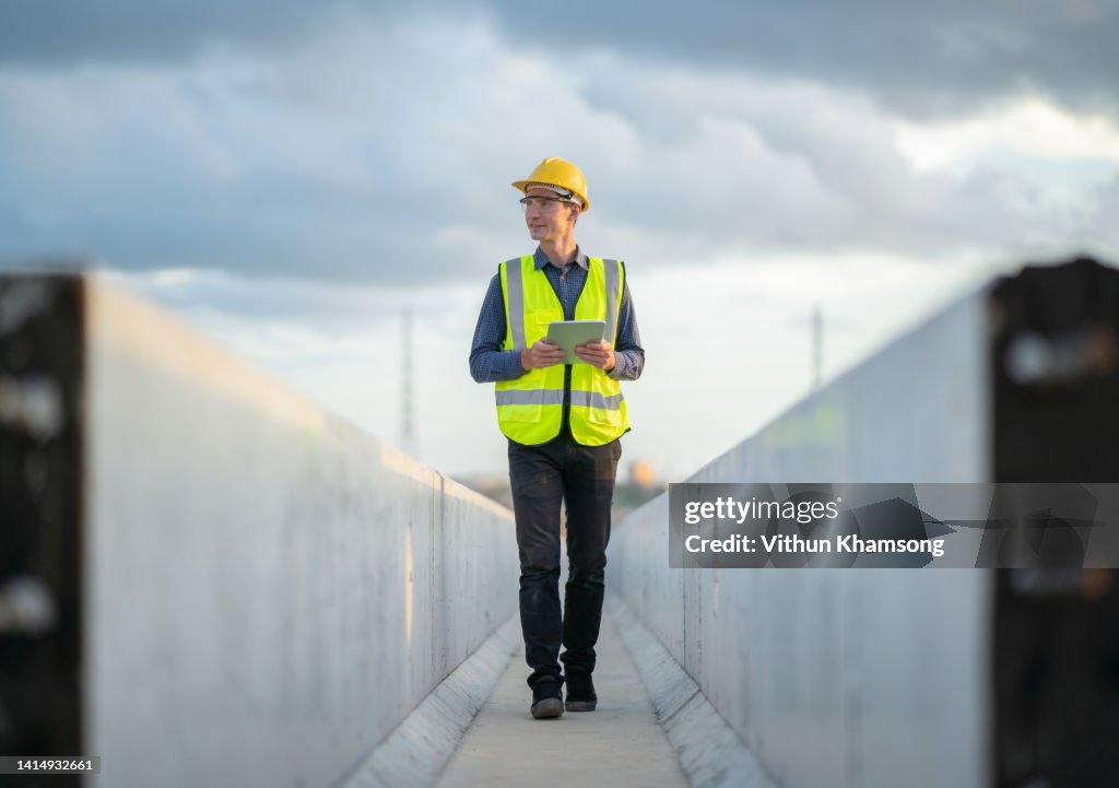 Male engineer working with tablet at construction site.