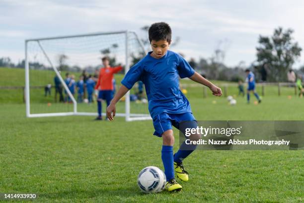 kid in field playing soccer game. - football league 個照片及圖片檔