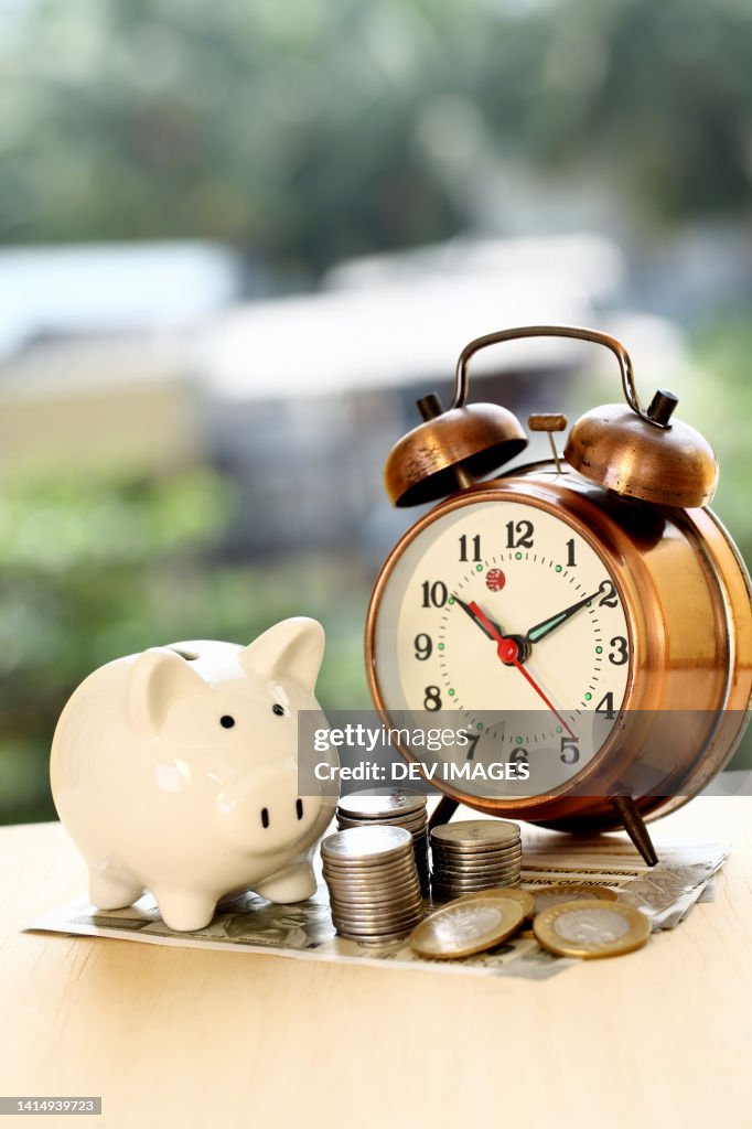 Stack of coins,Piggy bank and Alarm clock-Concept of money savings