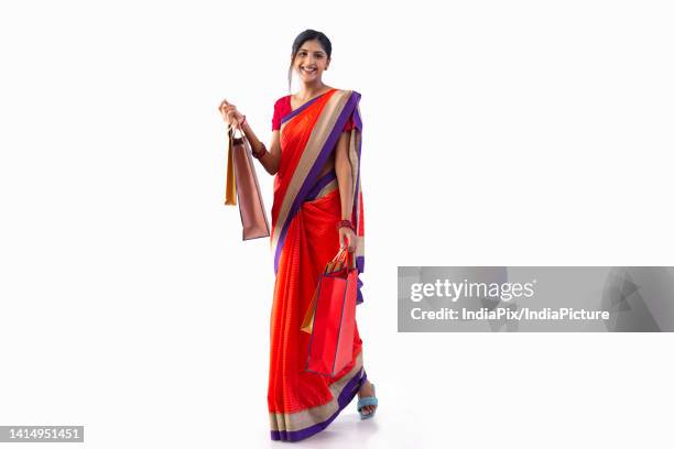 portrait of young cheerful woman with shopping bags - 民族衣装 ストックフォトと画像