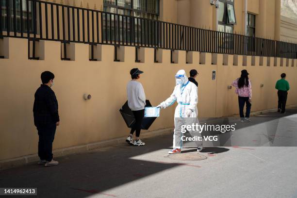 Local residents queue up for COVID-19 nucleic acid tests on August 15, 2022 in Lhasa, Tibet Autonomous Region of China. Lhasa will extend...