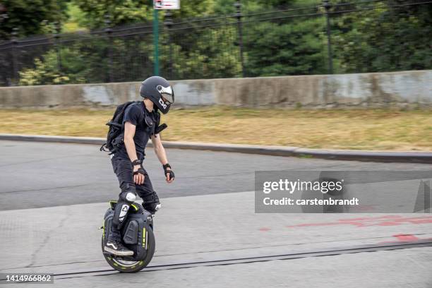 young man with crash helmet on a monowheel - monowheel stockfoto's en -beelden