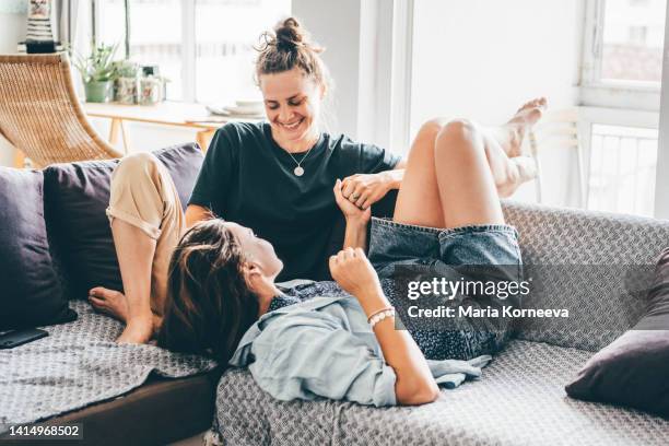 female couple enjoying time together on a sofa. - lesbians stock-fotos und bilder