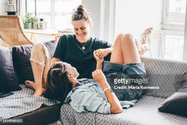 female couple enjoying time together on a sofa. - lésbica imagens e fotografias de stock