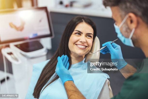 dentist and patient in dentist office - dentist patient stock pictures, royalty-free photos & images
