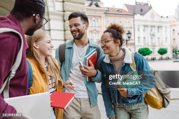 multi-ethnic group of students talking in front of university - study abroad stock pictures, royalty-free photos & images