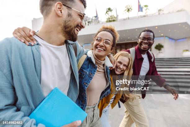 cheerful multi-ethnic group of students on the street - mid adult stock pictures, royalty-free photos & images