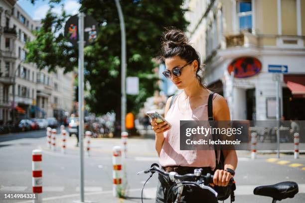 woman in berlin kreuzberg checking her smart phone - german stock pictures, royalty-free photos & images