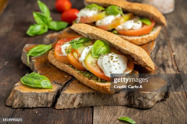 tomato and mozzarella in wholemeal ciabatta bread - caprese salad stock pictures, royalty-free photos & images