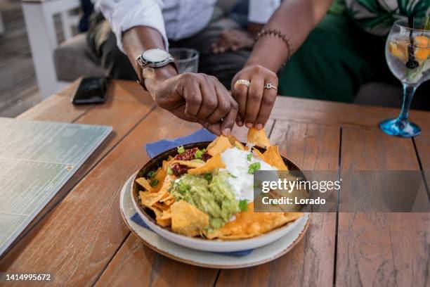 compartilhando comida vegana nachos restaurante - nachos - fotografias e filmes do acervo