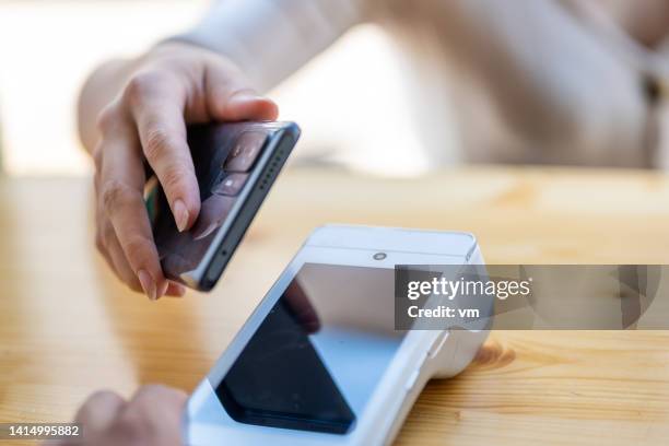 woman paying for her drink in a bar with a smartphone - white smart phone stock pictures, royalty-free photos & images