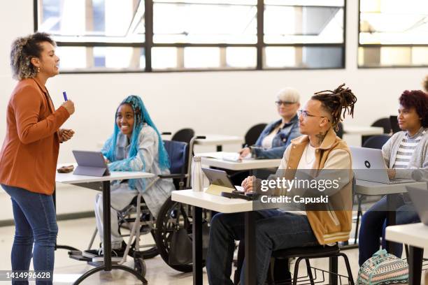 curly haired professor teaching class - inclusive classroom stockfoto's en -beelden