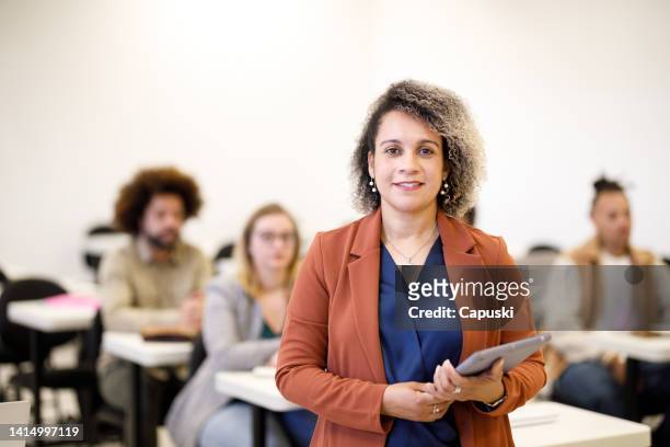 university professor holding a tablet in front of class - professor stock pictures, royalty-free photos & images