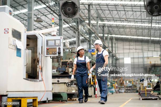 two engineers walking through an automated factory and talking - women in stem foto e immagini stock