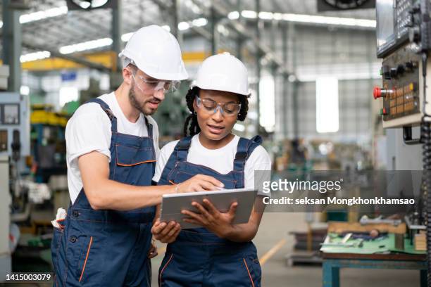 multiracial group of engineers are making discussion at a cnc machine about the production process change to improve quality and productivity in the automobile industry. - trainee program stock pictures, royalty-free photos & images
