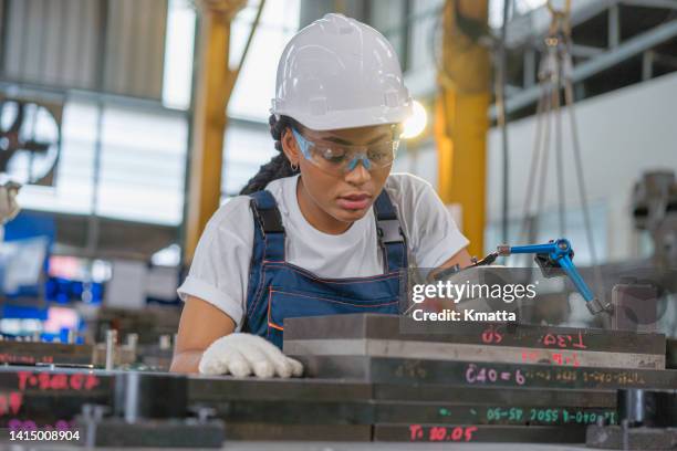 production operator performing quality control of a tooling. she's measuring its dimensions with a dial indicator. - 目盛板 ストックフォトと画像