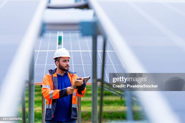 engineer working at solar farm using tablet computer verify completeness of installation work. - inspectors stock pictures, royalty-free photos & images