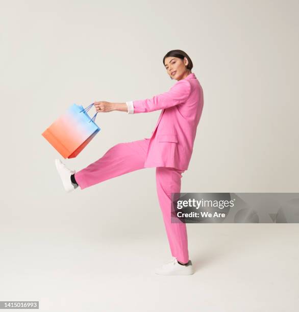 woman striding out with shopping bag - fazendo compras imagens e fotografias de stock