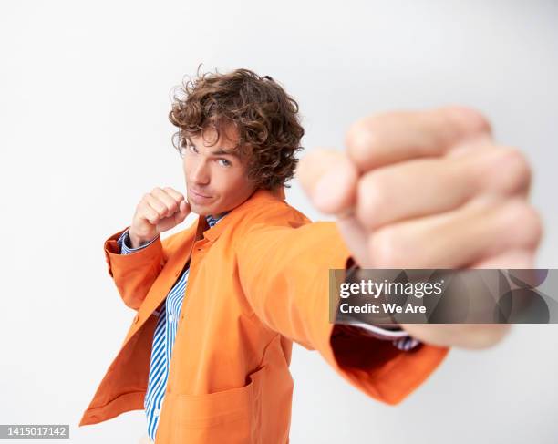 man punching towards the camera - puñetazo fotografías e imágenes de stock