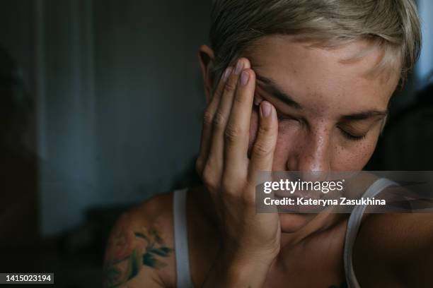 a dramatic dark closeup portrait of a young woman - negative emotion foto e immagini stock